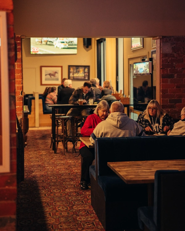 Customers enjoying eating meals at The Queen of the West Sports Bar.